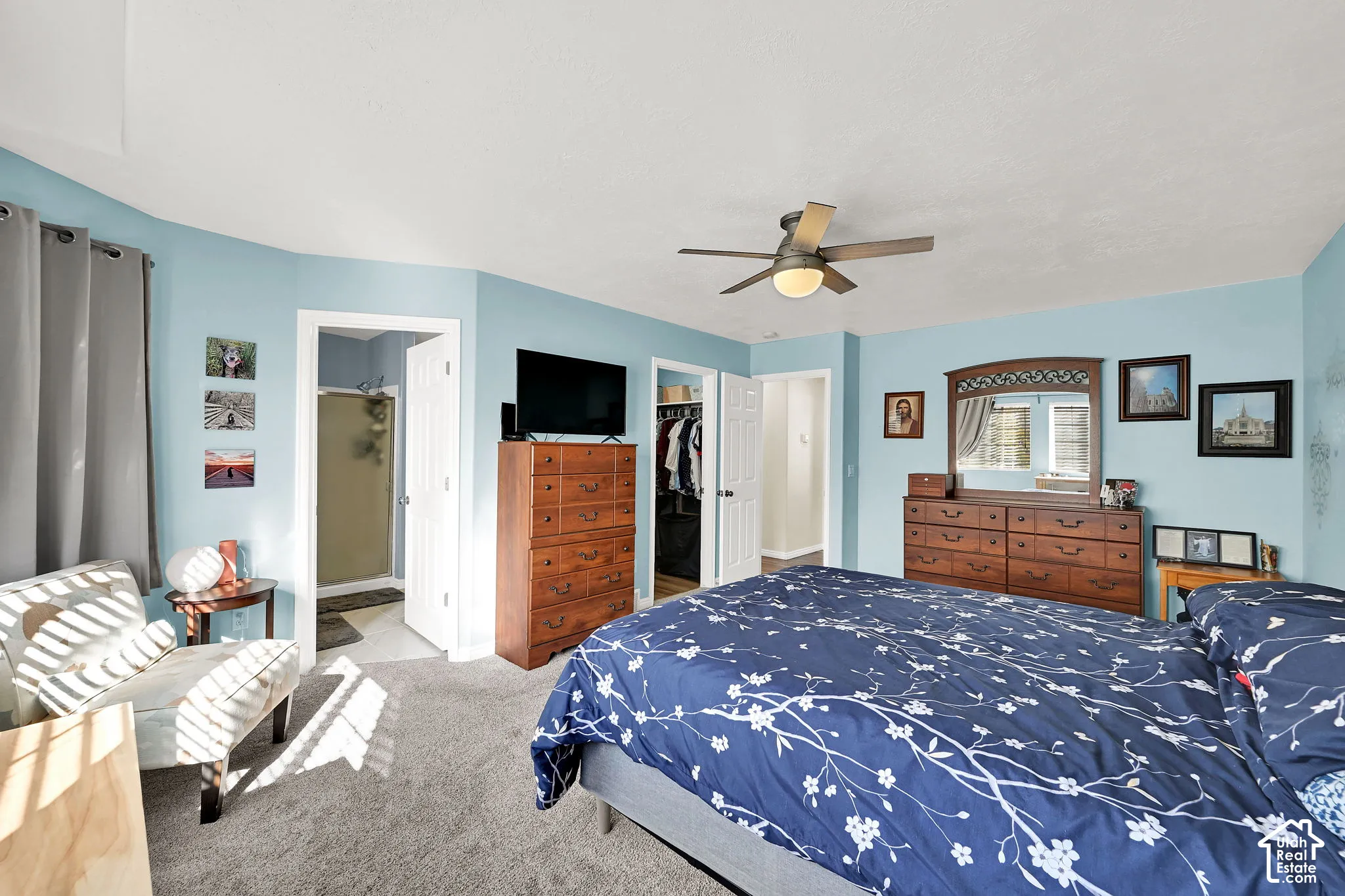 Spacious room featuring neutral carpeting, a ceiling fan with integrated lighting, and multiple interior doorways
