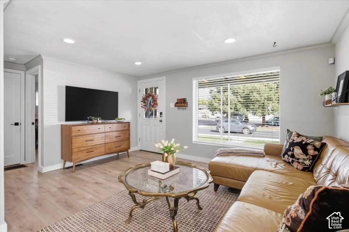 Living area featuring wood-finish flooring, recessed lighting, and a large picture window