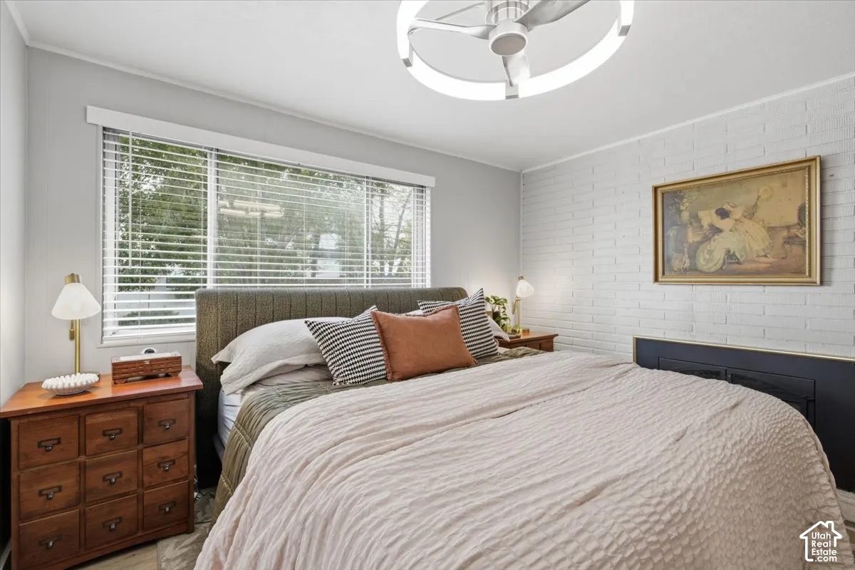 Painted brick accent wall featuring a black base, horizontal window blinds, and a contemporary circular flush-mount ceiling fixture