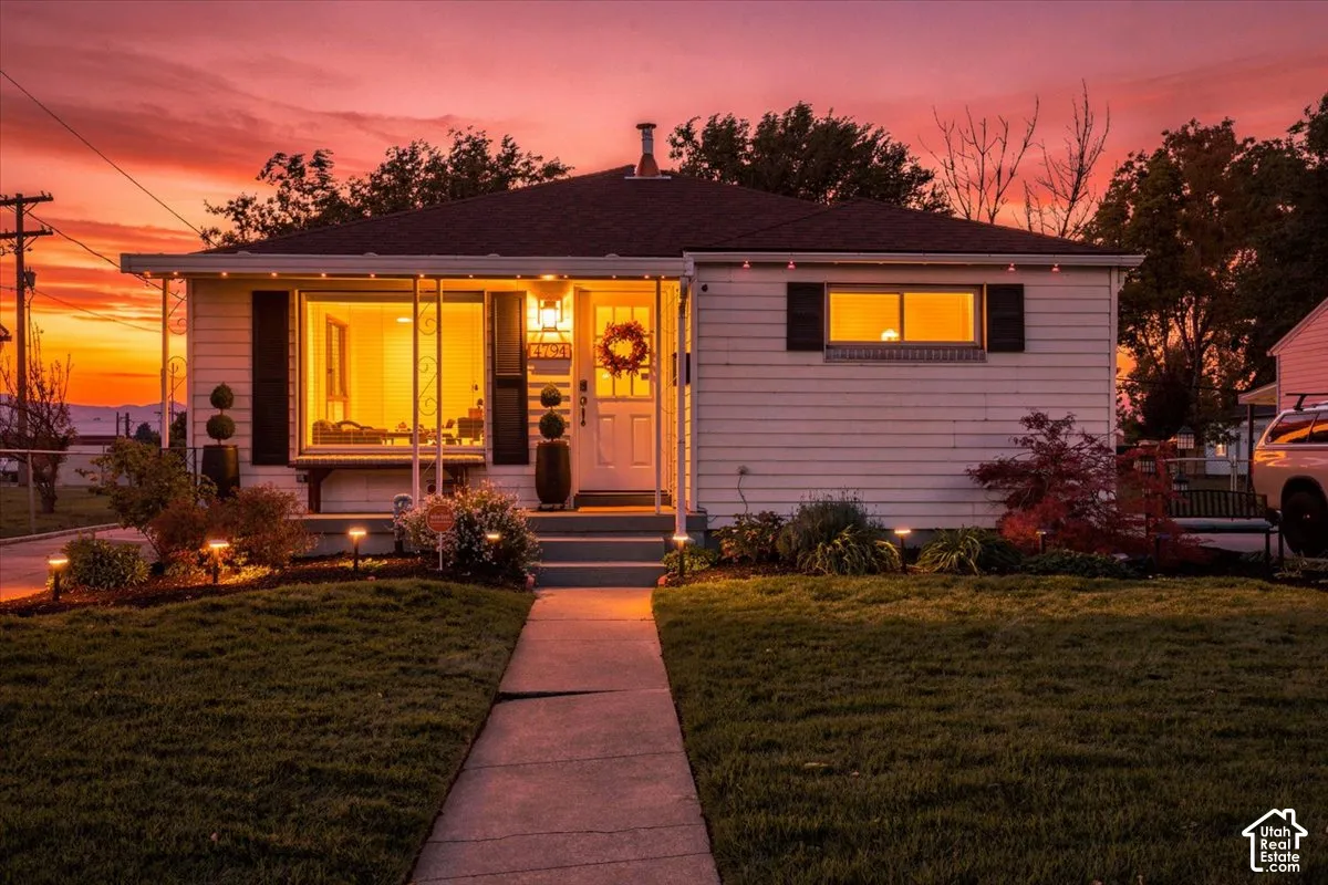Single-story residence featuring horizontal siding, decorative shutters, a concrete walkway, and a covered front porch