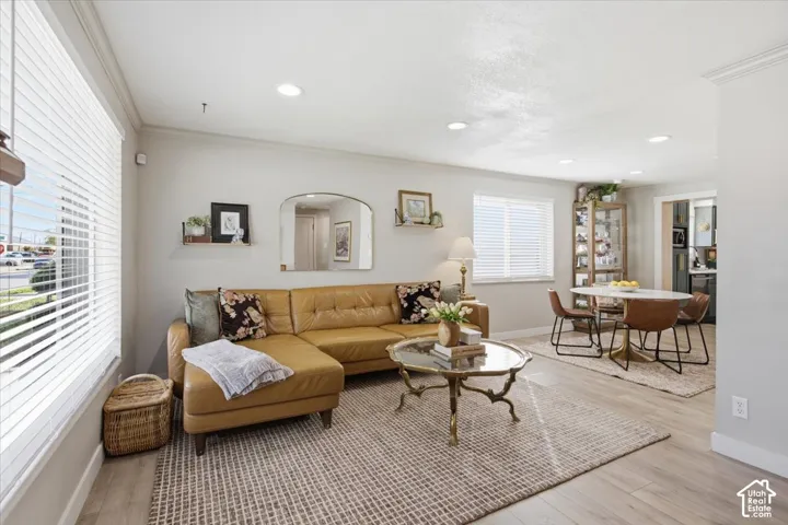 Neutral-toned walls, wood-finish flooring, recessed lighting, and multiple windows with horizontal blinds