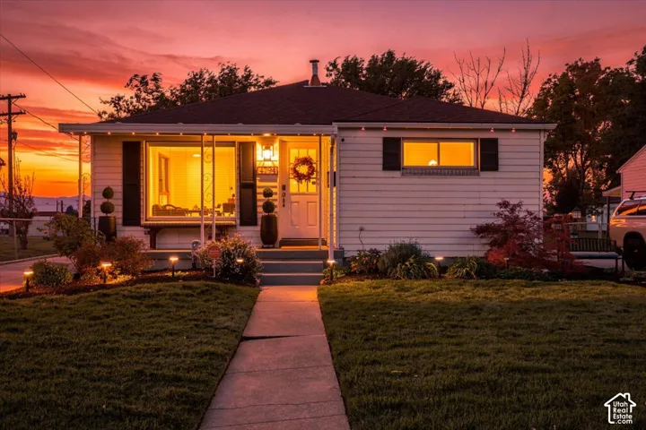 Single-story residence featuring horizontal siding, decorative shutters, a concrete walkway, and a covered front porch