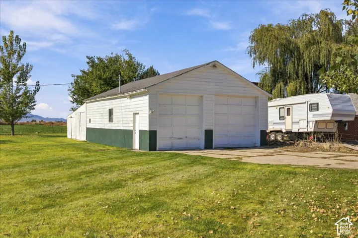 Detached two-car garage featuring dual overhead doors, a gabled roofline, lap siding, and a concrete driveway