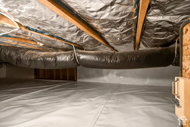 Crawl space featuring a moisture-resistant vapor barrier, reflective foil insulation, and flexible ductwork