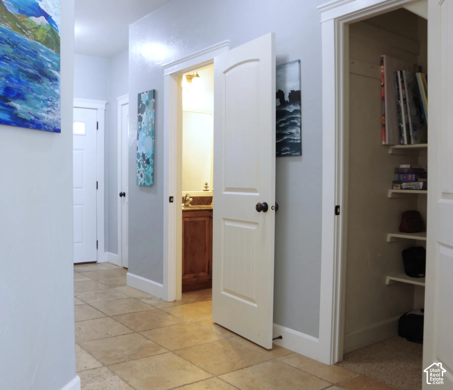 Neutral-toned tile flooring, solid-core two-panel interior doors, and built-in wall shelving