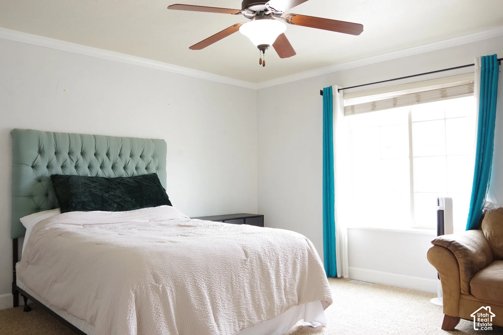Room featuring neutral wall tones, crown molding, wall-to-wall carpeting, and a ceiling fan with integrated lighting