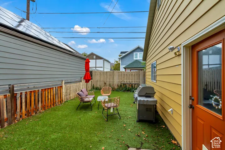 Enclosed backyard featuring synthetic turf and perimeter wood fencing