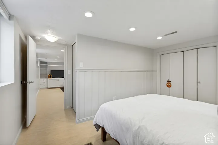 Room featuring recessed lighting, paneled wainscoting, and a multi-panel sliding closet
