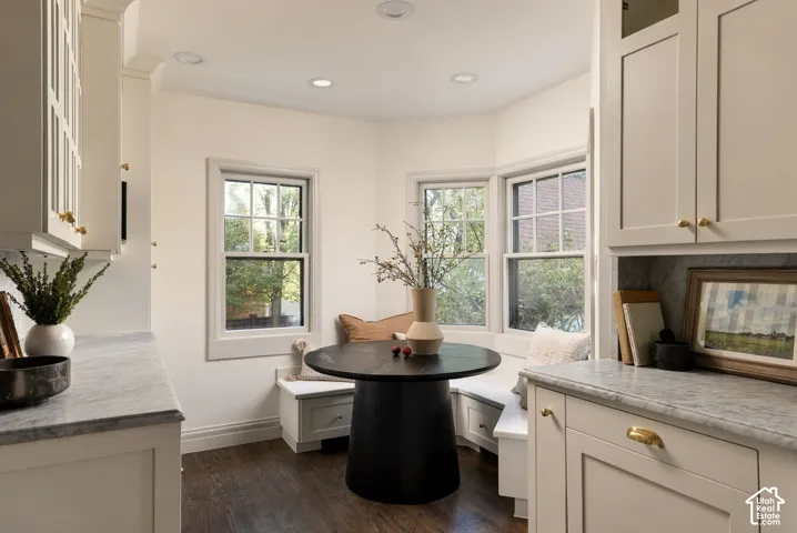 Custom built-in cabinetry, stone countertops, integrated bench seating, wood-finish flooring, and multi-pane windows