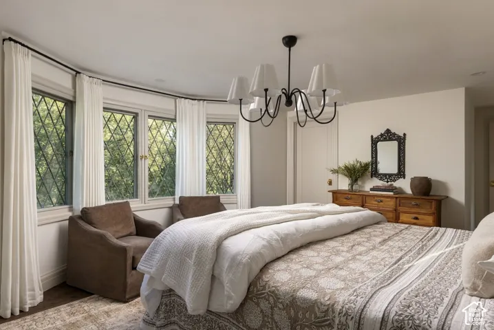 Bay window with diamond-pane glass detailing, crown molding, and a six-arm metal chandelier with fabric shades