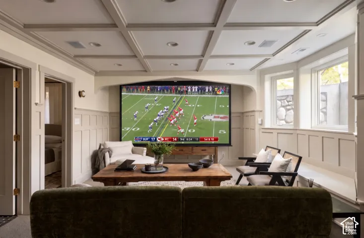 Coffered ceiling with integrated recessed lighting, extensive wainscoting, built-in window seating, and an arched wall niche
