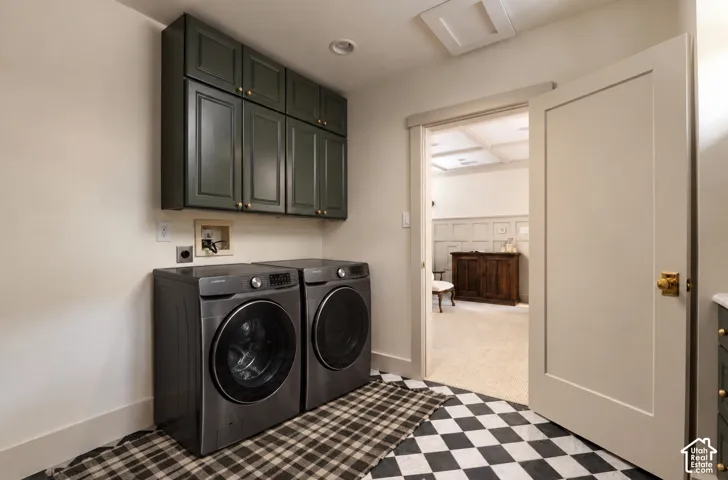 Utility space featuring dark-toned, wall-mounted cabinetry, a checkered tile floor, and a shaker-style interior door