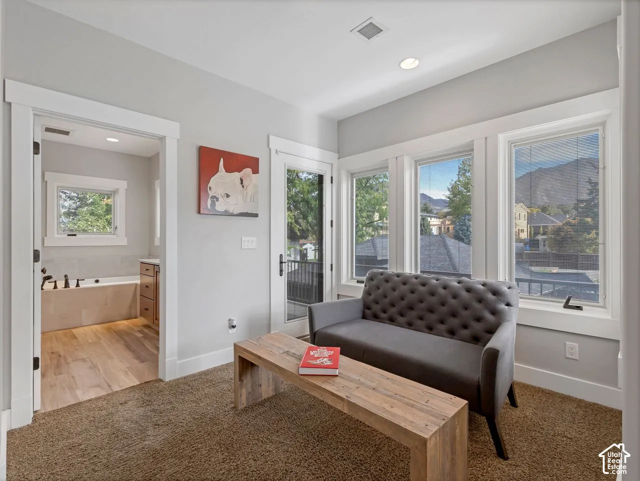 Interior space featuring expansive windows with mountain backdrop, glass-panel exterior door, and wood-finish flooring in the bathroom