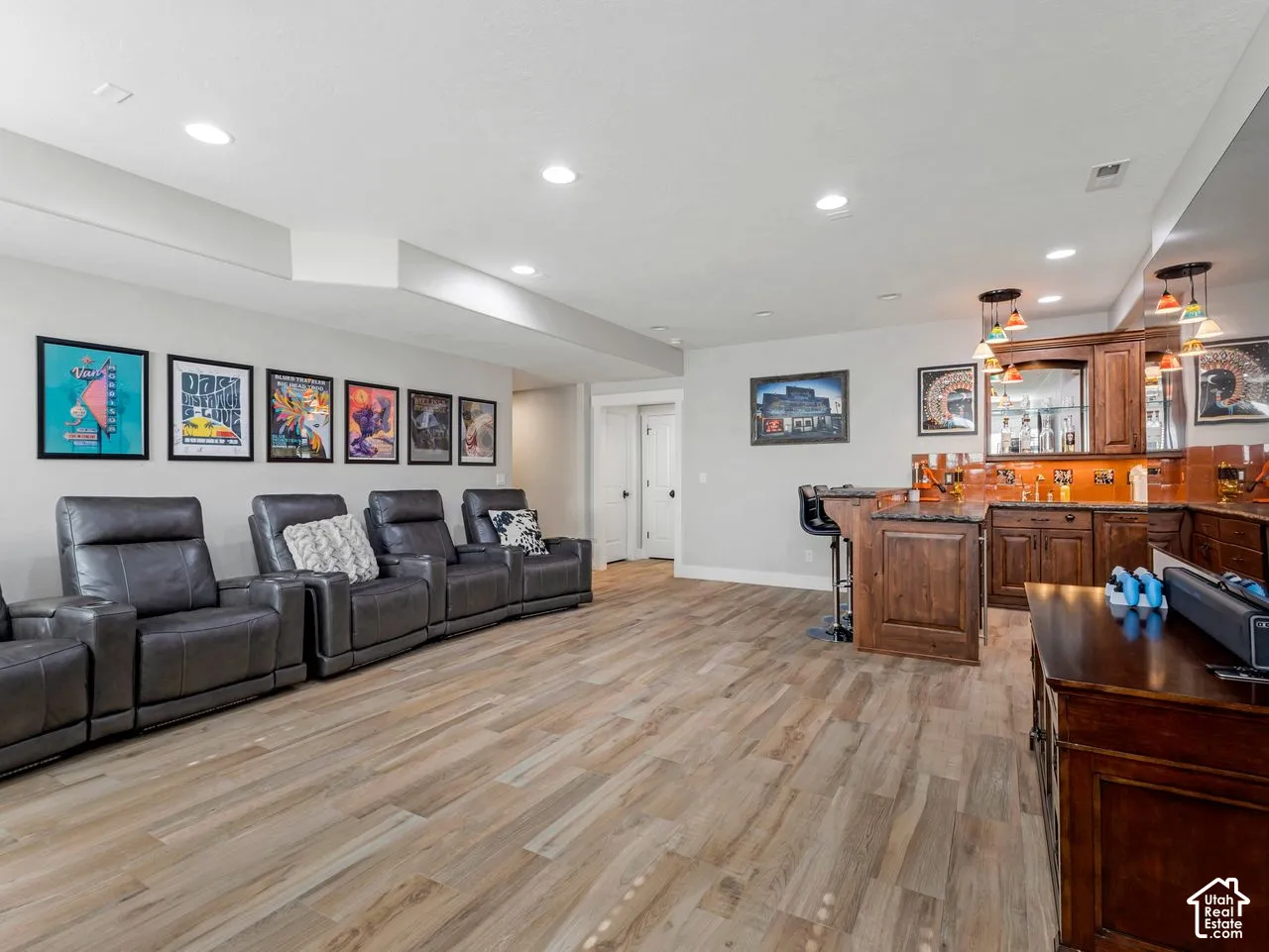 Open-concept living space featuring wood-finish flooring, recessed lighting, and a built-in wet bar with cabinetry and a countertop