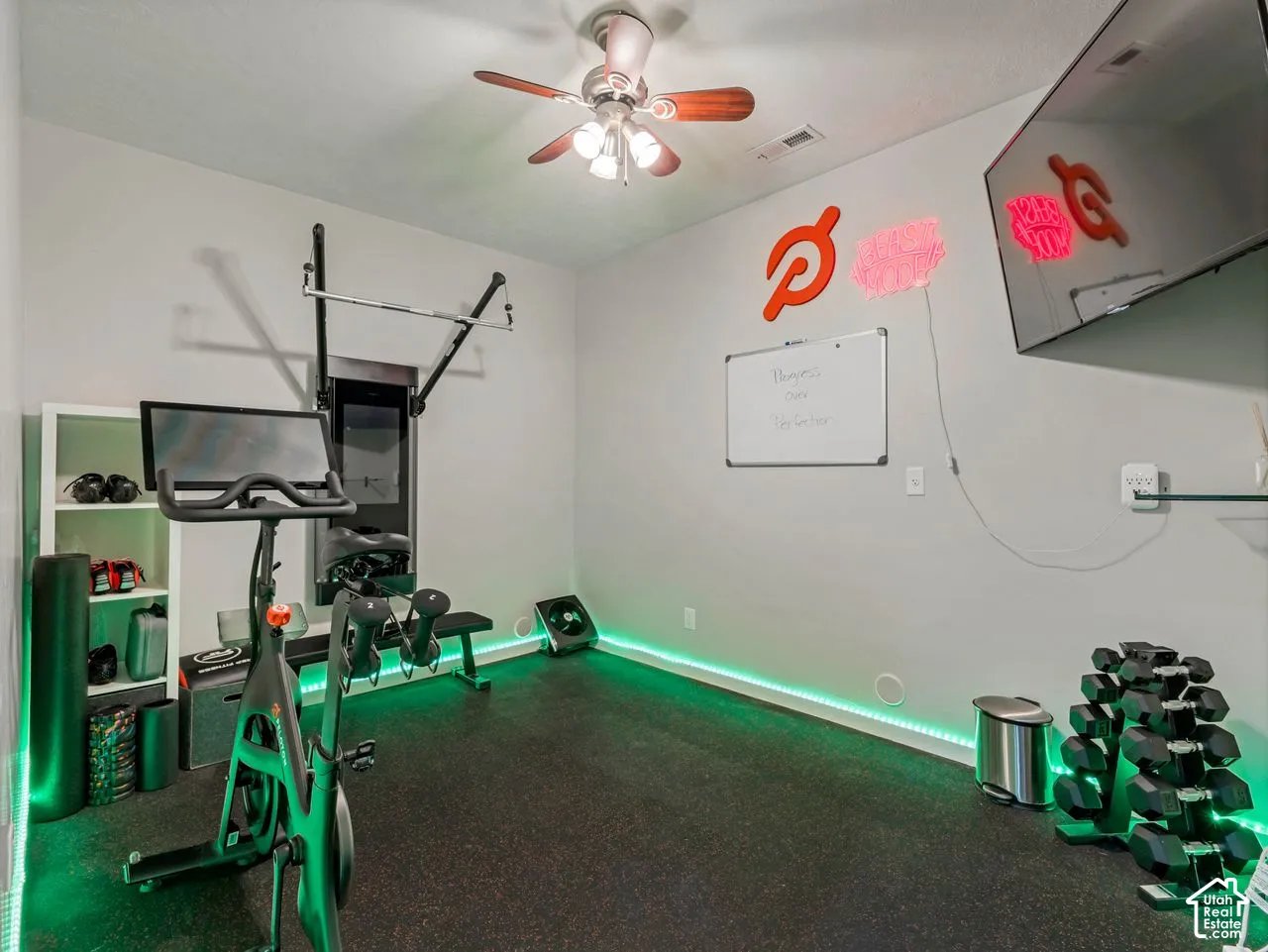 Room featuring dark resilient flooring and a ceiling-mounted light fixture with a fan