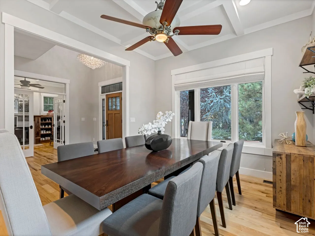 Coffered ceiling with a center-mounted ceiling fan, wide-plank wood-finish flooring, multi-pane glass entry door, and recessed lighting
