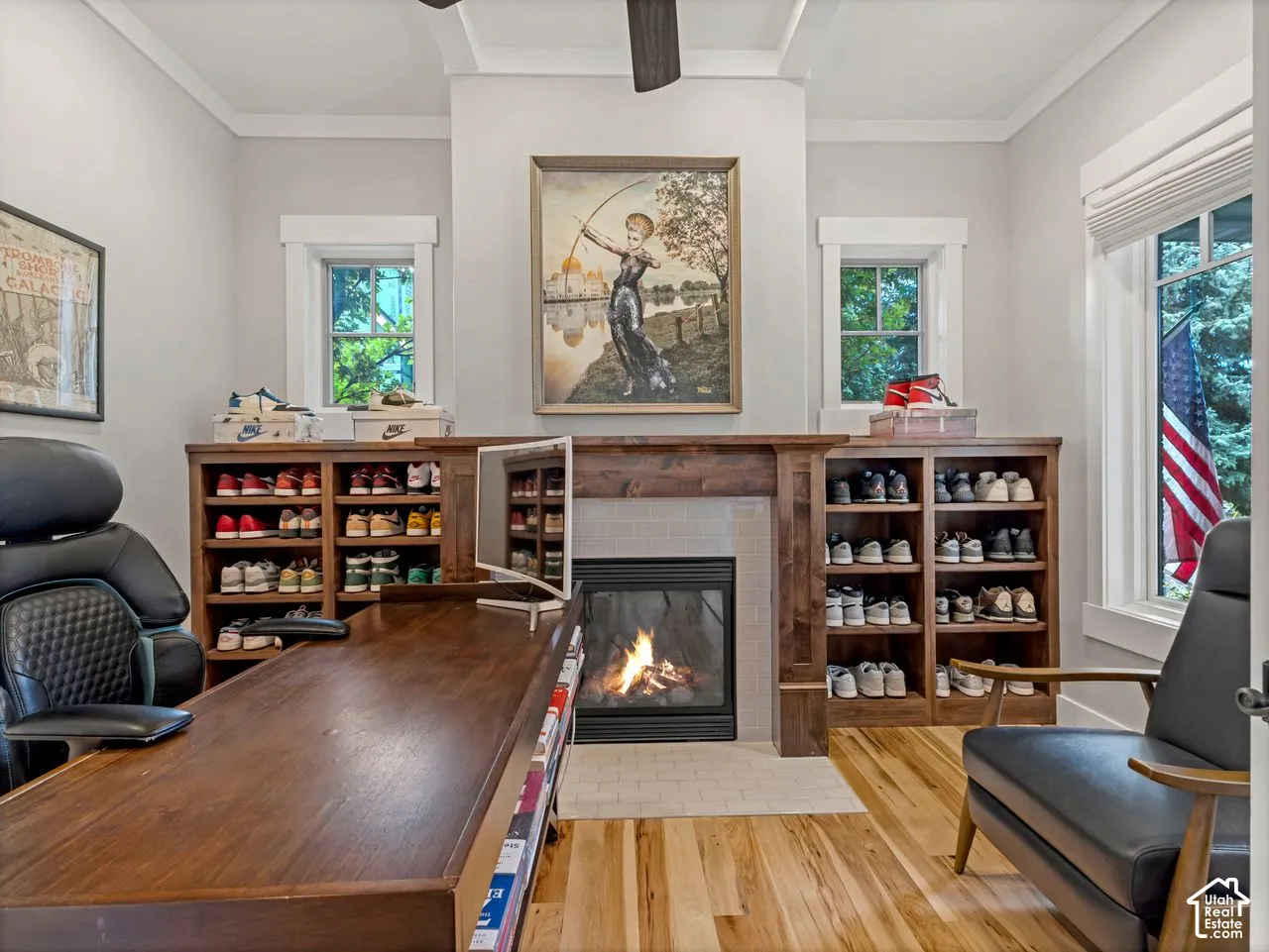 Room featuring built-in wood shelving, a fireplace with a wood mantel, coffered ceiling, and wood-finish flooring