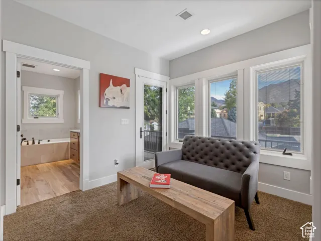 Interior space featuring expansive windows with mountain backdrop, glass-panel exterior door, and wood-finish flooring in the bathroom
