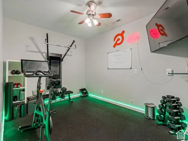Room featuring dark resilient flooring and a ceiling-mounted light fixture with a fan