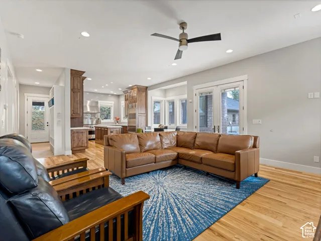 Open-concept space featuring wood-finish flooring, recessed lighting, a ceiling fan, wood cabinetry, and double glass-paned doors