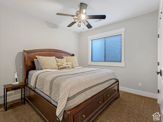 Neutral wall color, carpeted flooring, window with thick casing, and ceiling fan with integrated lighting