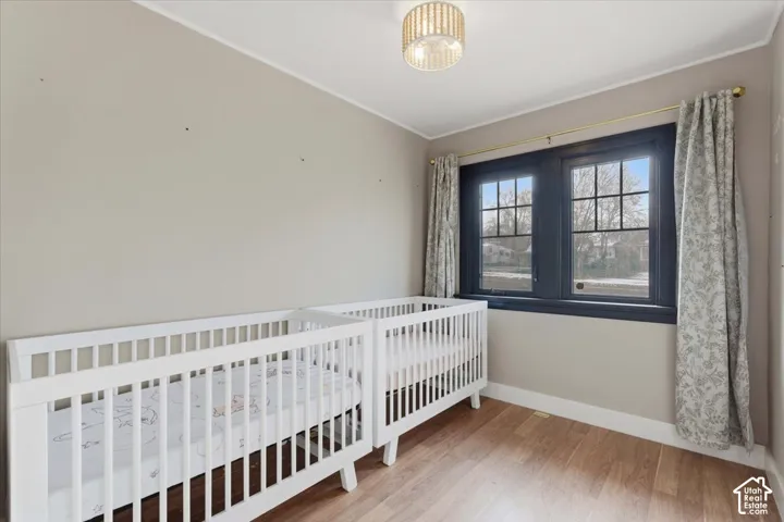 Room featuring wood-finish flooring, dark-trimmed multi-pane windows, and a flush-mount drum ceiling light fixture