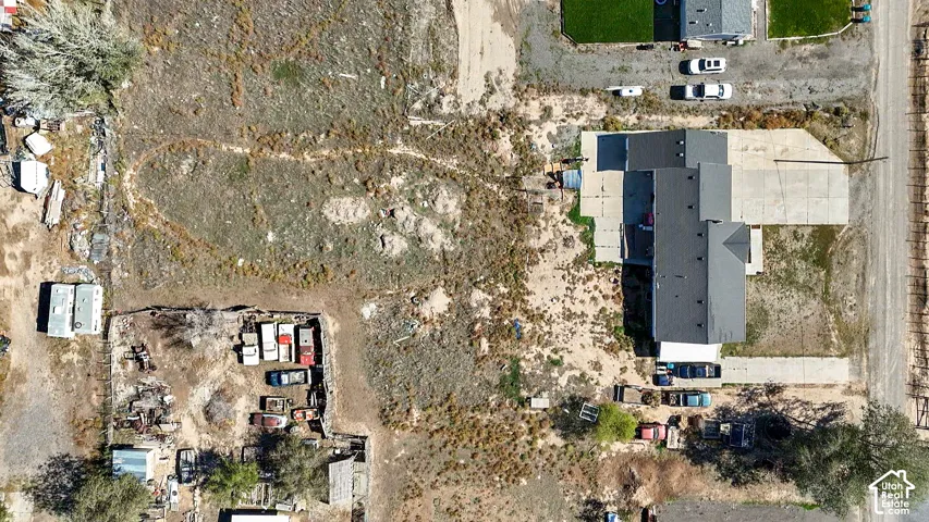 Aerial perspective of a detached residential structure featuring a multi-gable roofline and an expansive, level lot