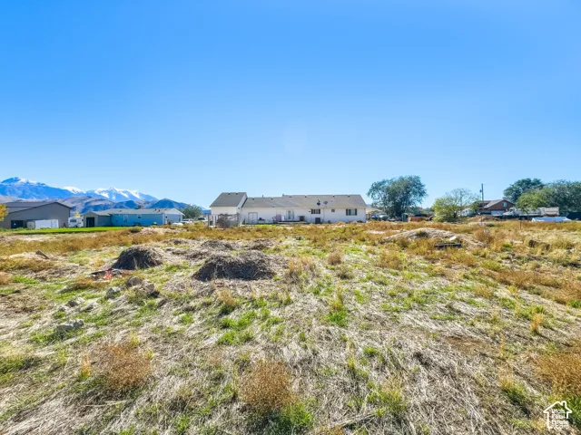 Expansive lot featuring terrain with native grasses and mountain peaks in the distance