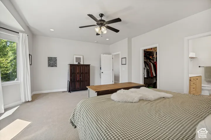 Neutral-toned interior space featuring recessed lighting, a ceiling fan with integrated lighting, wall-to-wall carpeting, and a walk-in closet with built-in shelving