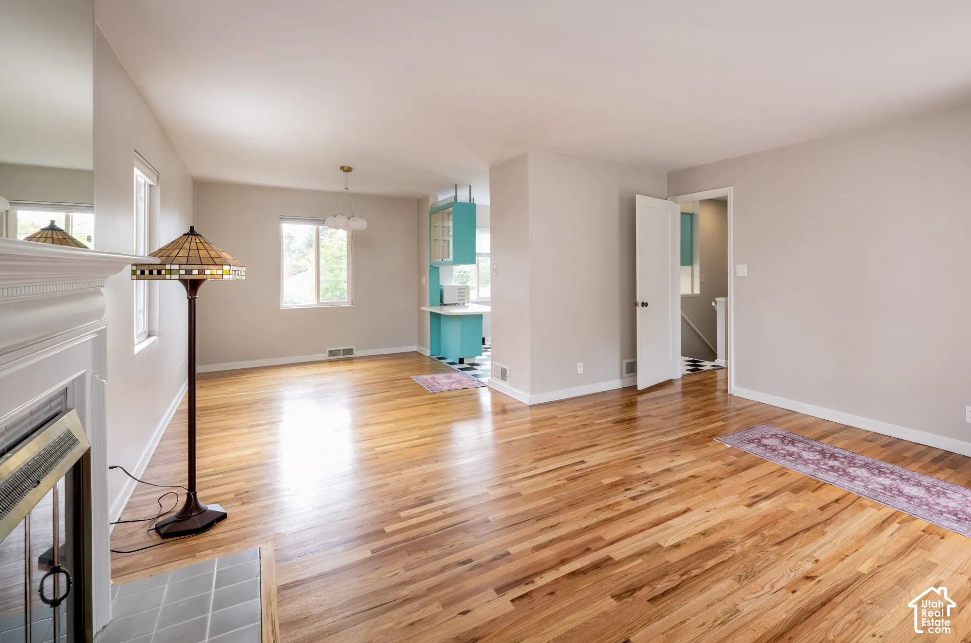Living area featuring wood-finish flooring, a fireplace with a decorative mantel, and neutral wall paint