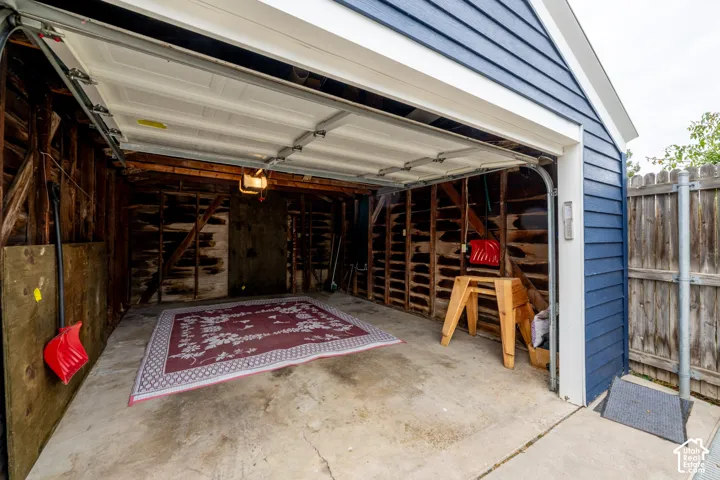 Detached garage featuring blue lap siding, a concrete floor, and an overhead sectional door
