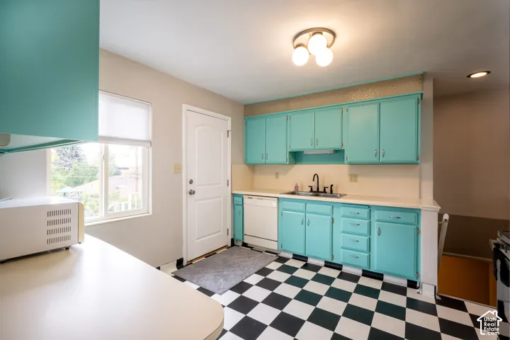 Kitchen featuring custom cabinetry, checkerboard tile flooring, dual-basin sink with a matte black faucet, and built-in dishwasher