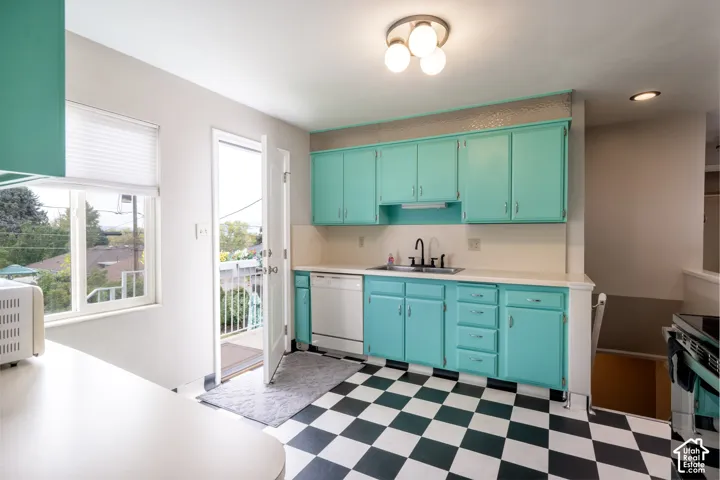 Kitchen featuring custom-color cabinetry, checkerboard flooring, integrated dishwasher, and matte black plumbing fixtures