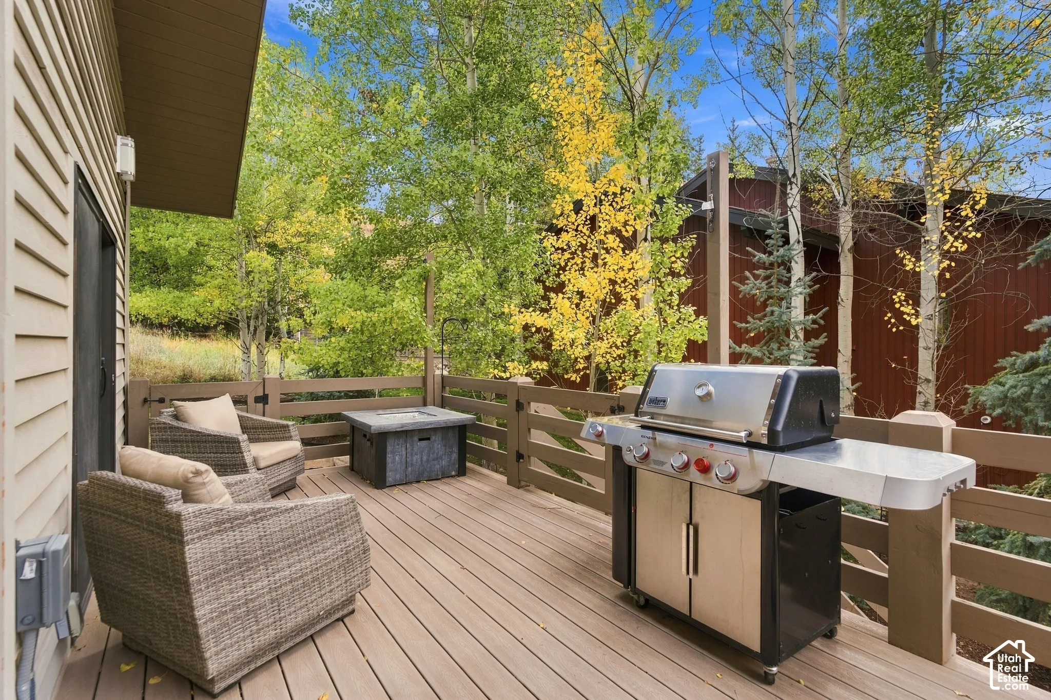 Elevated deck featuring composite decking, horizontal wood-style railing, and exterior wall-mounted lighting