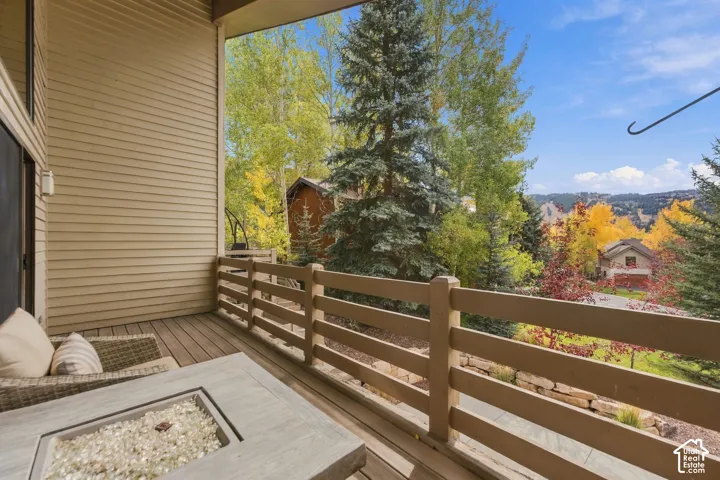 Covered balcony featuring horizontal wood-slat railing, horizontal siding, wood-finish decking, and mountain-range scenery