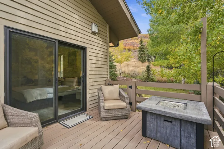 Composite decking, horizontal slat railing, sliding glass door, and exterior siding, accented by a square concrete fire table