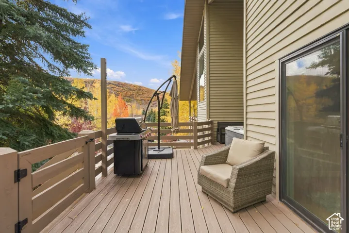 Elevated outdoor deck featuring horizontal wood-tone railing, low-maintenance composite decking, and sliding glass door access
