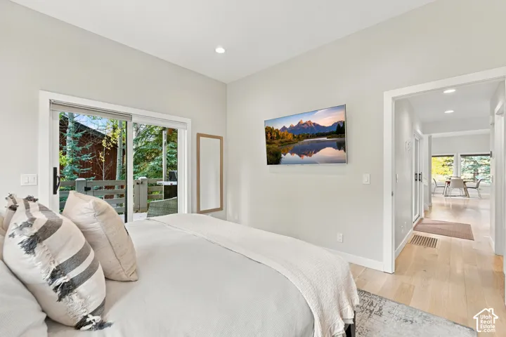 Light-filled room featuring wood-finish flooring, recessed lighting, and a sliding glass door with access to an exterior deck