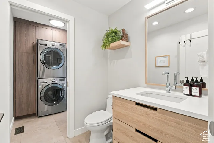 Bathroom featuring a wood-finish floating vanity with a quartz countertop, integrated rectangular sink, and chrome faucet, paired with a wood-framed mirror