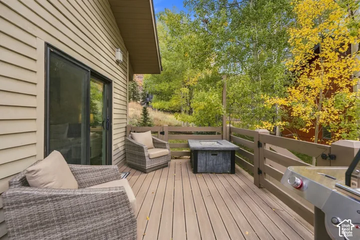 Exterior deck with horizontal wood-finish railing, sliding glass door, and vinyl siding