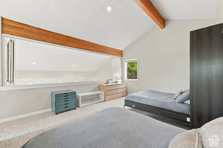 Vaulted ceiling featuring exposed wood beams and recessed lighting