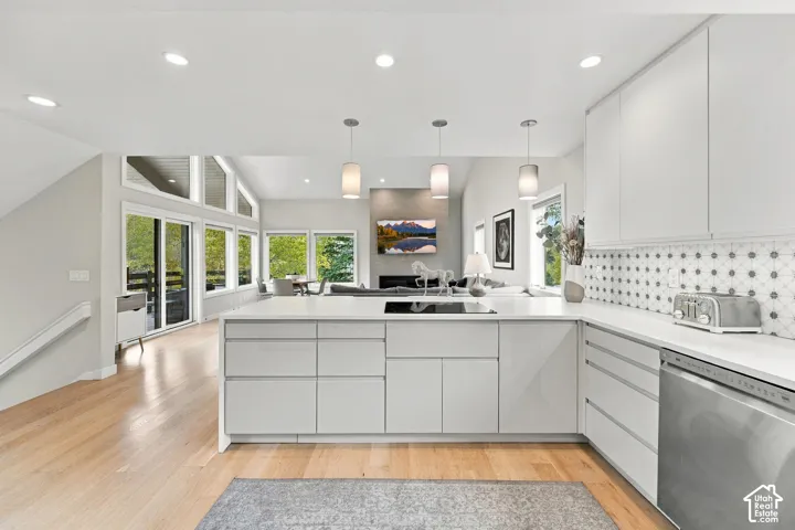Kitchen featuring flat-panel cabinetry, quartz countertops, patterned tile backsplash, recessed lighting, and wood-finish flooring