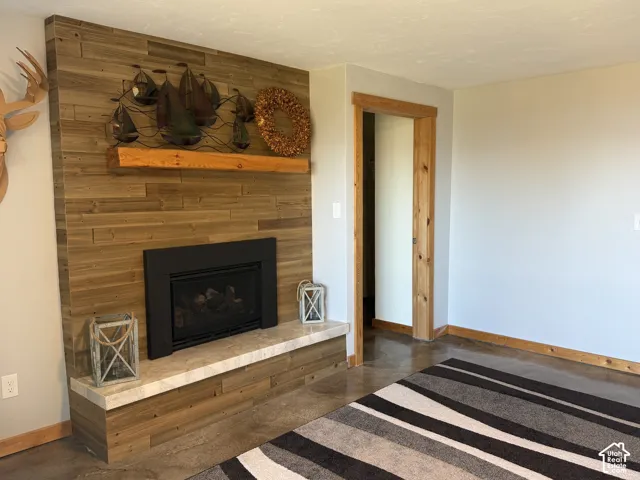 Fireplace feature wall with horizontal wood-panel cladding, stone-surface hearth, and natural wood mantel
