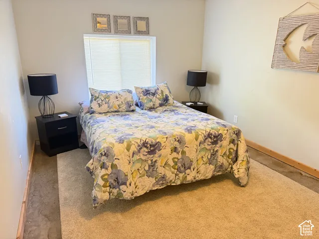 Neutral interior space featuring a recessed window with installed horizontal blinds and natural wood-finish trim