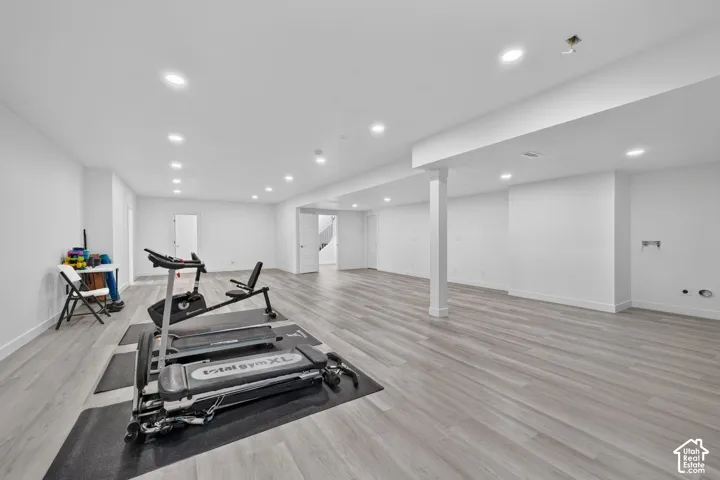 Open-concept interior featuring wood-finish flooring, recessed lighting, and a support column