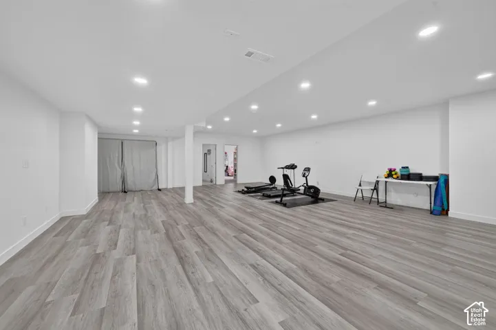 Open-concept room featuring wood-finish flooring, recessed lighting, and a neutral color palette