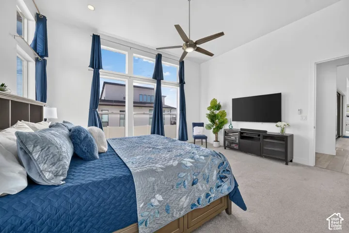 High ceilings, large multi-pane windows, and a ceiling fan with integrated lighting