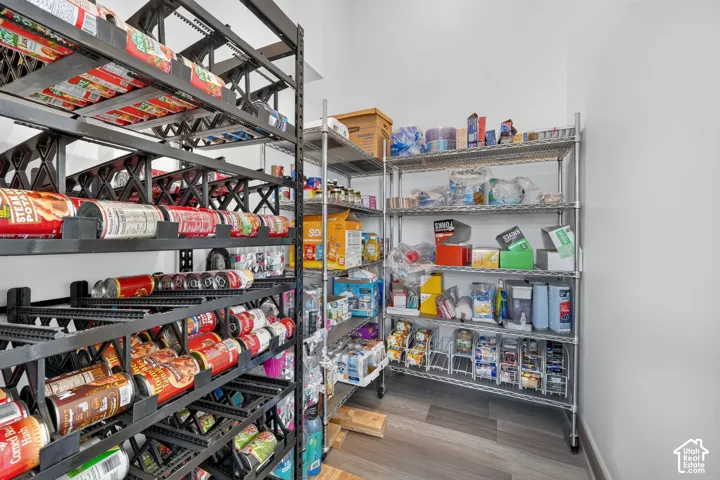 Pantry featuring wood-finish flooring and wire shelving systems