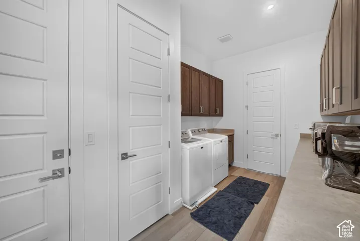 Laundry room featuring wood-finish cabinetry, solid-surface countertops, wood-finish flooring, and shaker-style interior doors with satin nickel hardware