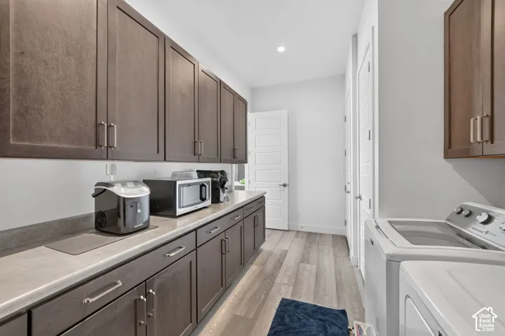Laundry room featuring dark wood-finish cabinetry, neutral solid-surface countertops, wood-finish flooring, and multi-panel doors
